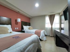 テキスキアパンにあるSaint George Hotel - Spa & Temazcalのベッド2台とテレビが備わるホテルルームです。