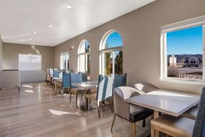 a dining room with tables and chairs and windows at Best Western Grants Inn in Grants