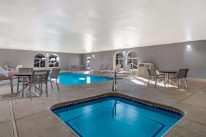 a swimming pool with a table and chairs and a dining room at Best Western Grants Inn in Grants