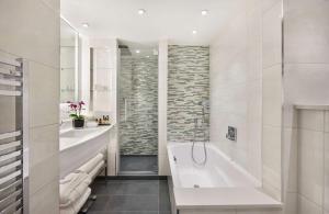 a bathroom with a tub and a sink at Hyatt Regency London Albert Embankment in London