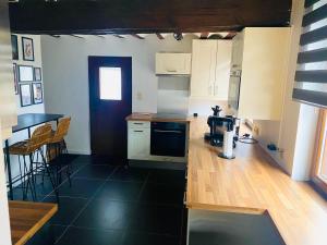 a kitchen with white cabinets and a black floor at L'antre du loup in Stavelot