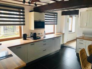 a kitchen with white cabinets and a counter top at L'antre du loup in Stavelot