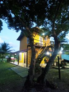 a yellow house with a staircase on the side of it at Casa temporada na praia Joia do Atlântico - Ilhéus - Ba in Ilhéus