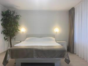 ein Bett in einem Schlafzimmer mit zwei Lichtern und einer Pflanze in der Unterkunft Vila Suzana in Venus