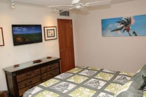 een slaapkamer met een bed en een dressoir bij KIHEI BEACH, #303 condo in Kihei