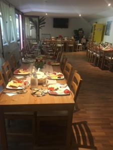 a dining room with tables and chairs with plates of food at Suzana Garden in Venus