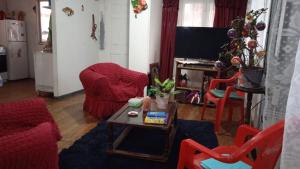 Hostal " Donde Alicia " في كارتاخينا: غرفة معيشة مع كراسي حمراء وطاولة قهوة