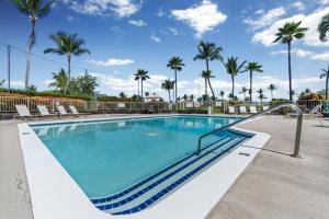 een zwembad met stoelen en palmbomen bij Big Island Keauhou Punahele by Coldwell Banker Island Vacations in Kailua-Kona