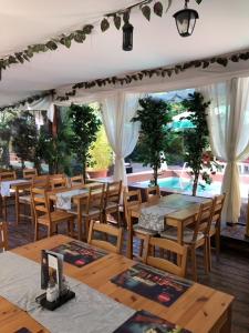 ein Restaurant mit Holztischen und -stühlen und einer Terrasse in der Unterkunft Suzana Garden in Venus
