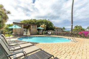 - une piscine avec 2 chaises longues à côté d'une clôture dans l'établissement Maui Vista by Coldwell Banker Island Vacations, à Kihei