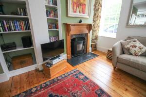 a living room with a fireplace and a couch at Bossy Castle in Boscastle