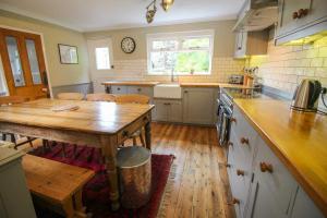 a kitchen with a wooden table and a wooden floor at Bossy Castle in Boscastle