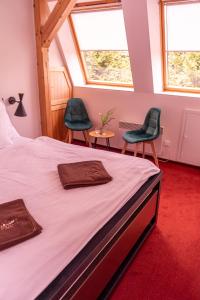 Hajnice的住宿－Penzion Tadeášovy domky，一间卧室配有一张带两把椅子的床和窗户。