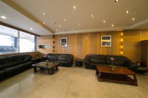 a living room with black leather couches and tables at Jiuning Business Hotel in Tainan