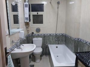 a bathroom with a sink and a toilet and a tub at compound city towers elwaha in Cairo