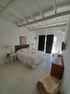 Dormitorio blanco con cama y mesa en Casa Bikini, en Punta del Este