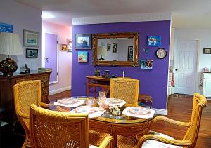 comedor con mesa, sillas y pared púrpura en The Rose Inn, en Santee