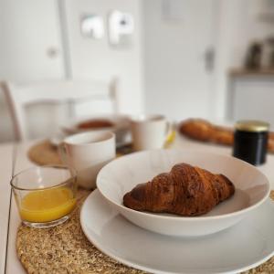 a bowl of bread and a glass of orange juice on a table at Héol in Saint Malo