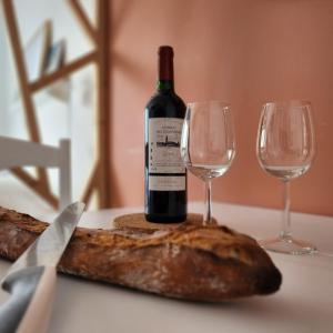 een fles wijn en twee wijnglazen op een tafel bij Héol in Saint-Malo