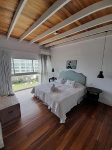 1 dormitorio con cama grande y ventana grande en Casa Bikini, en Punta del Este