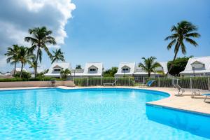 een zwembad met palmbomen en huizen bij Baie Nettle Beach Villa 2080 in Saint Martin