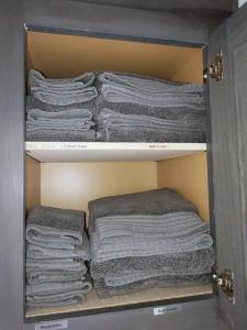 a cabinet filled with folded towels in a closet at Twin Lakes Tiny Homes of Okmulgee in Okmulgee