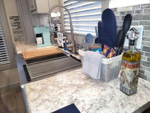 a kitchen counter with a sink and a bottle of wine at Twin Lakes Tiny Homes of Okmulgee in Okmulgee