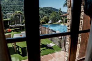 a view of a swimming pool from a window at Casa les Pomeretes in El Figaró