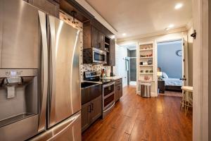 a kitchen with a stainless steel refrigerator and wooden floors at Luxury new Home/Museum/Med. Ctr/dwn twn*FAMILIES in Houston