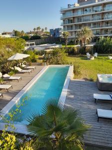 una piscina con tumbonas y un edificio en Casa Bikini, en Punta del Este