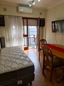 1 dormitorio con cama, mesa y comedor en Zona Aldrey en Mar del Plata