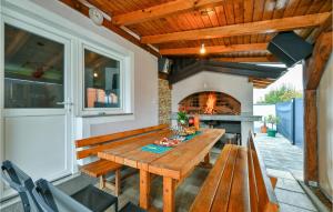 d'une terrasse avec une table en bois et une cheminée. dans l'établissement Amazing Home In Dugo Selo With Jacuzzi, à Dugo Selo