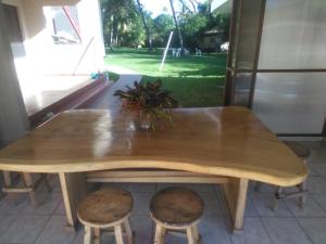 een houten tafel met twee krukken en een tafel bij Beach On The Rocks in El Zonte