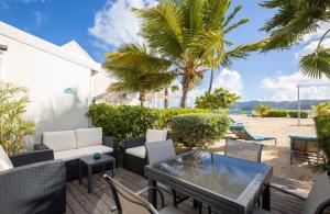 eine Terrasse mit Stühlen und Tischen am Strand in der Unterkunft Baie Nettle Beach Villa 2080 in Saint Martin