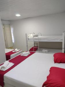 2 camas en una habitación con sábanas rojas y blancas en Nalu Beach Hotel pousada, en Fortaleza