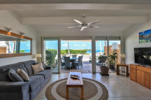 a living room with a couch and a tv at Modern Beach Villa 1150 in Saint Martin