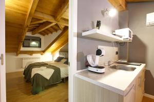 una cocina con fregadero y una cama en una habitación en Cuencaloft La Plazeta, en Cuenca