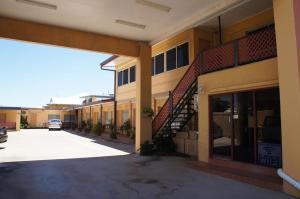 a building with a staircase in a parking lot at Ayrline Motel in Ayr