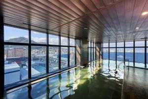 a swimming pool in a building with windows at Hakodate Kokusai Hotel in Hakodate