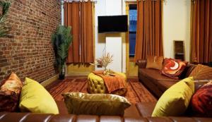 ein Wohnzimmer mit Sofa und Ziegelwand in der Unterkunft Rustic Sunset in New York