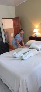 Una mujer parada en una cama con toallas. en Hotel Trianon en San José