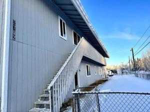 ein Gebäude mit einer weißen Treppe neben einem Zaun in der Unterkunft Comfortable 2BR Apt Central in Fairbanks