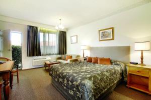 a hotel room with a bed and a desk at Hotel Bruce County in Mount Waverley +14 photos