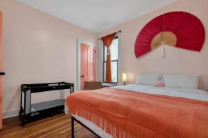 1 dormitorio con 1 cama con ventilador rojo en la pared en Peachy Paradise in East Rock Near DT/Yale, en New Haven
