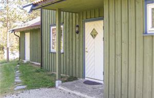a green building with a white door and a porch at Jervehiet - Hytte 4 in Øvre Ramse