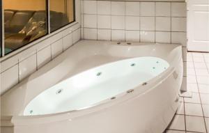 a white bath tub in a bathroom with a window at Jervehiet - Hytte 4 in Øvre Ramse