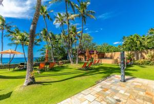 a garden with palm trees and a patio at Wailea Elua by Coldwell Banker Island Vacations in Wailea