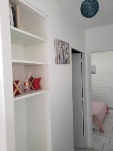 una stanza con pareti bianche e scaffali bianchi di ptit coin hibiscus2 a Pointe-Noire