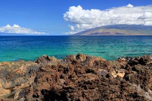 a view of the ocean with a mountain in the background at KIHEI SURFSIDE, #111 condo in Wailea