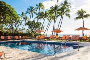 a swimming pool with chairs and umbrellas and the ocean at WAILEA ELUA, #2501 condo in Wailea